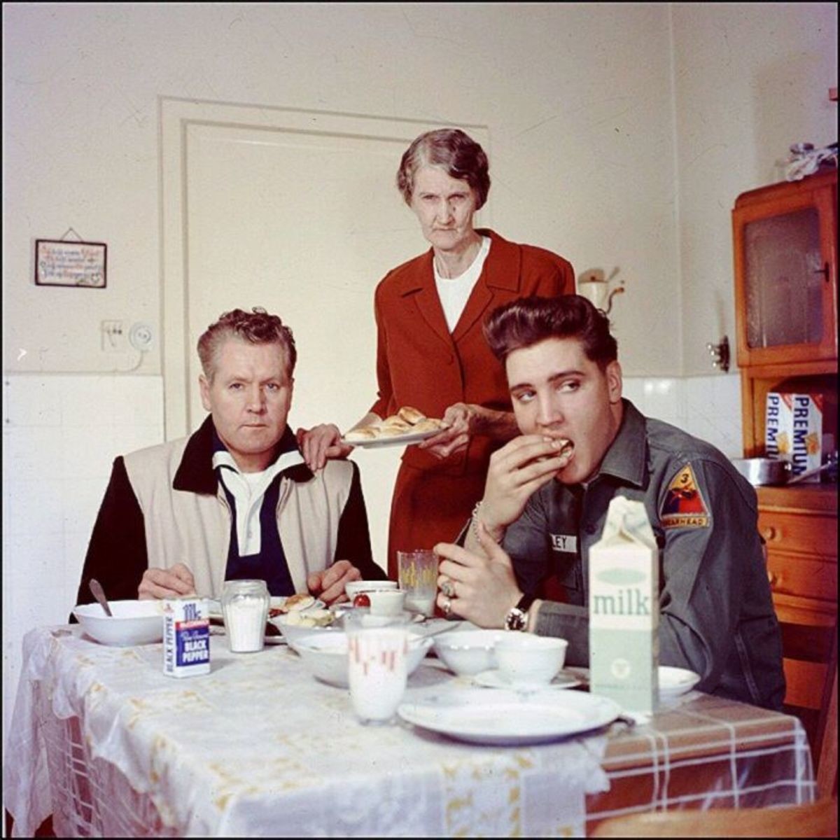 Elvis' parents look so disappointed. .. To me it looks like a photoshoot, you have the stern and angry looking parents and then the carefree and nonchalant Elvis eating and looking in the distance.